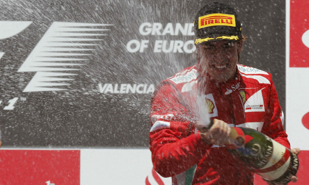 Ferrari Formula One driver Fernando Alonso of Spain sprays champagne during the podium ceremony after the European F1 Grand Prix at the Valencia street circuit June 24, 2012. Alonso won the European Grand Prix on Sunday to become the first repeat winner of the Formula One season after eight races. Finland's Kimi Raikkonen was second for Lotus with seven-times champion Michael Schumacher finishing third for Mercedes in his first appearance on the podium since 2006.  REUTERS/Albert Gea (SPAIN - Tags: SPORT MOTORSPORT)